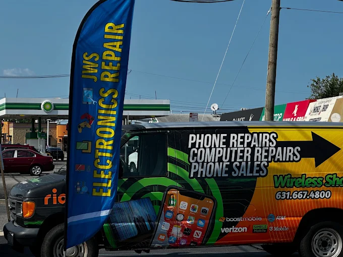 JWS Electronics Repair blue feather flag and the green and yellow Wireless Shack phone repair van parked outside the shop